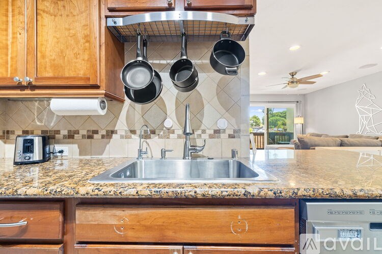 A kitchen with a marble countertop and wooden cabinets.