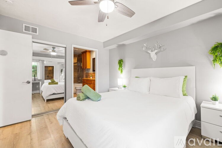 A bedroom with a large bed and a ceiling fan.