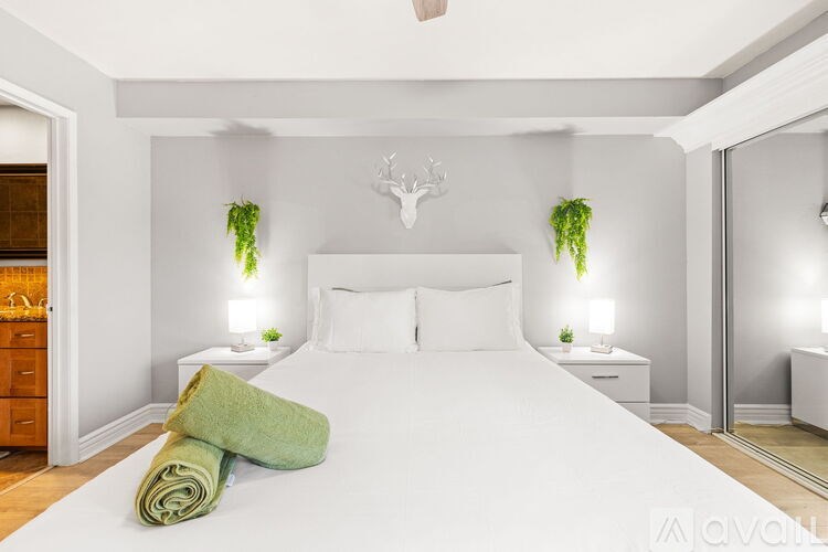 A bedroom with a large bed and a deer head on the wall.