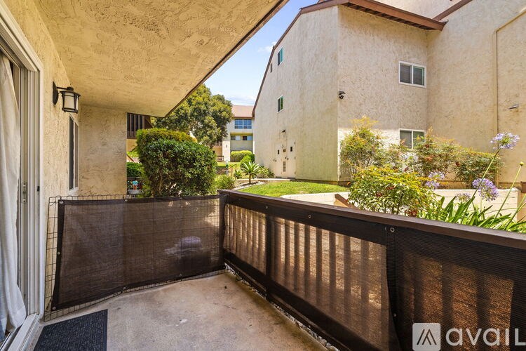 A balcony with a black railing and a mat on the floor.