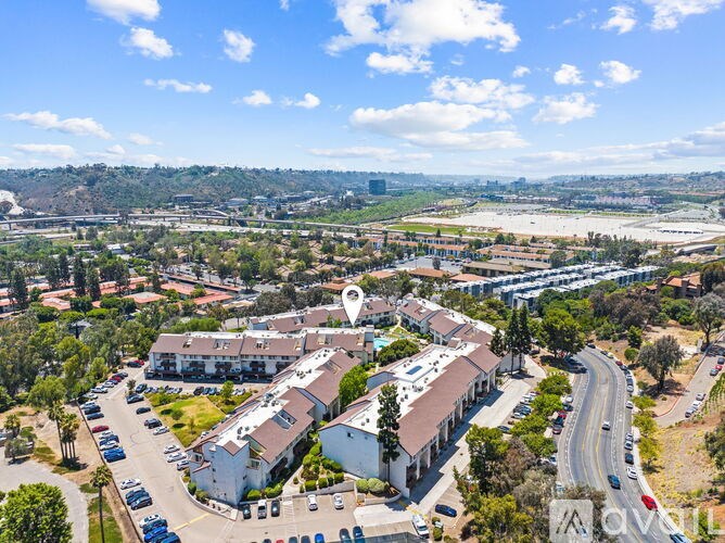 A bird's eye view of a residential area with a road passing through.