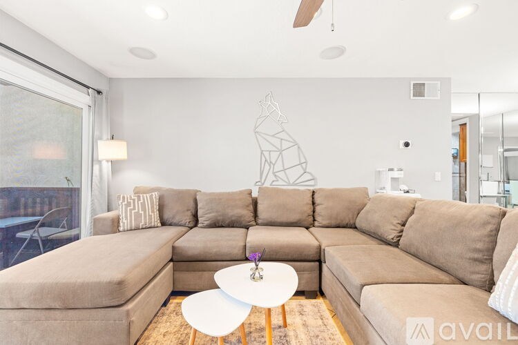 A living room with a large sectional sofa and a coffee table.