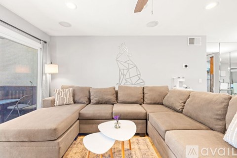 A living room with a large sectional sofa and a coffee table.