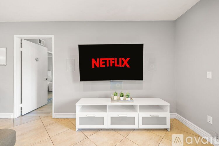 A living room with a white TV displaying the Netflix logo.