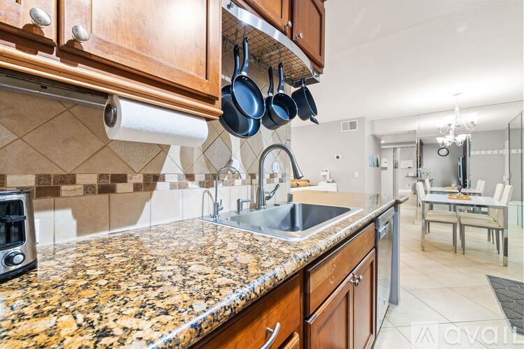 A kitchen with granite countertops and wooden cabinets.