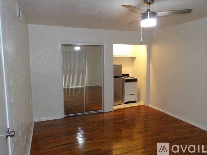A room with a ceiling fan and a sliding glass door leading to a balcony.