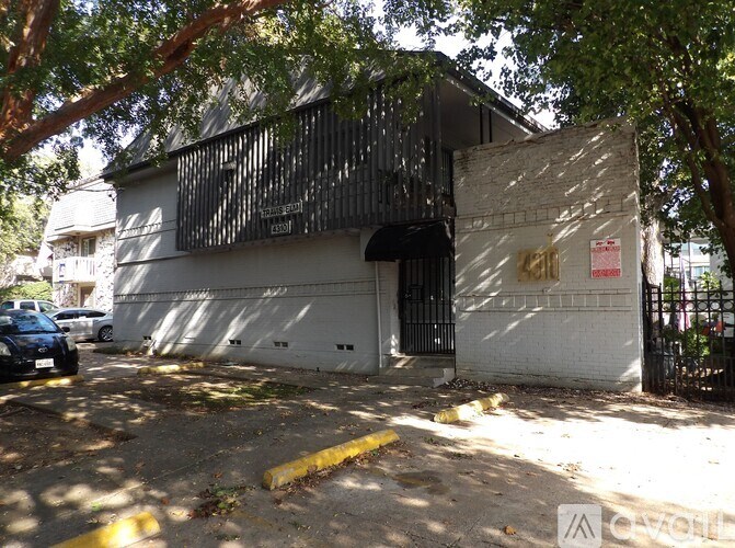 A white building with a black gate and a sign on it.