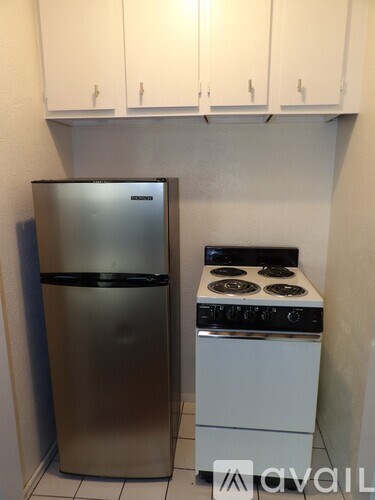 A kitchen with a stainless steel refrigerator and a white stove top oven.