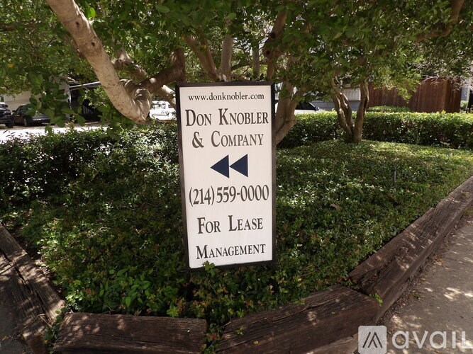 A sign for Don Knobler & Company is displayed in a garden.