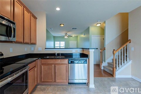 A kitchen with wooden cabinets and a black countertop.