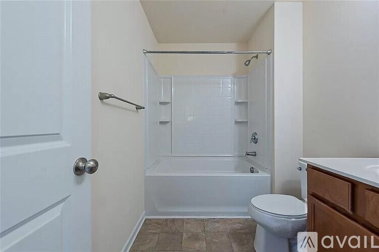 A bathroom with a toilet, a shower with a glass door, and a white door.