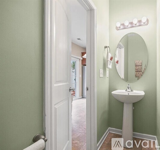 A bathroom with a white sink and a mirror with lights above it.