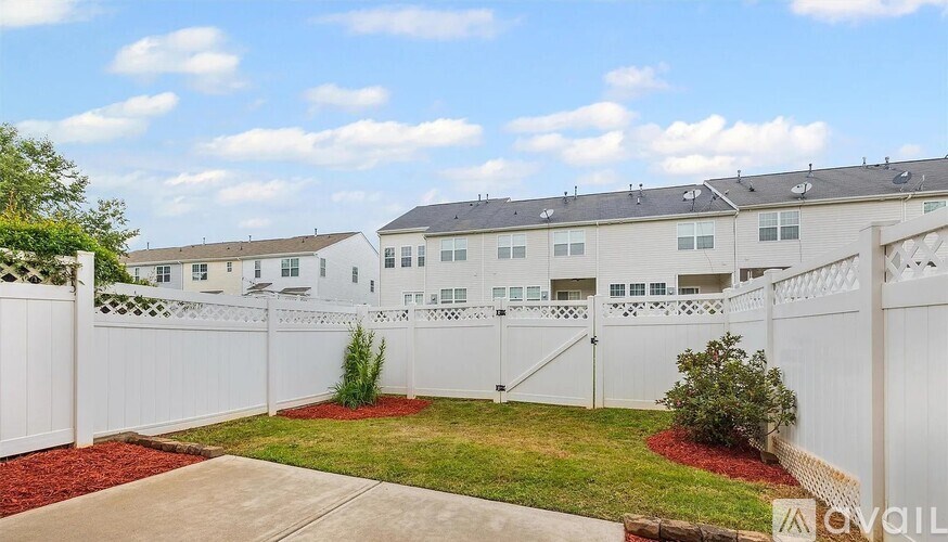 A white fence surrounds a building with multiple windows.