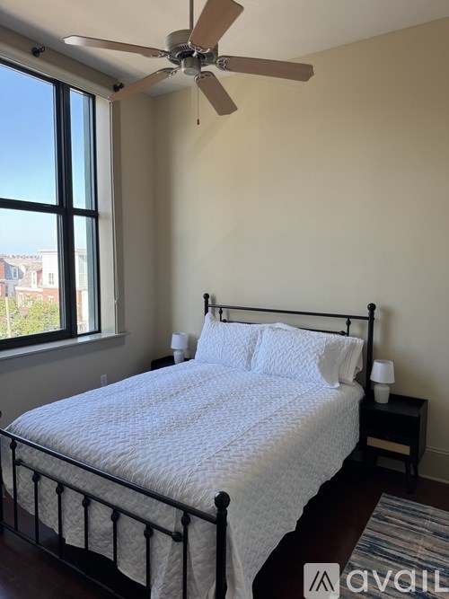 A bedroom with a bed, nightstand, and window.