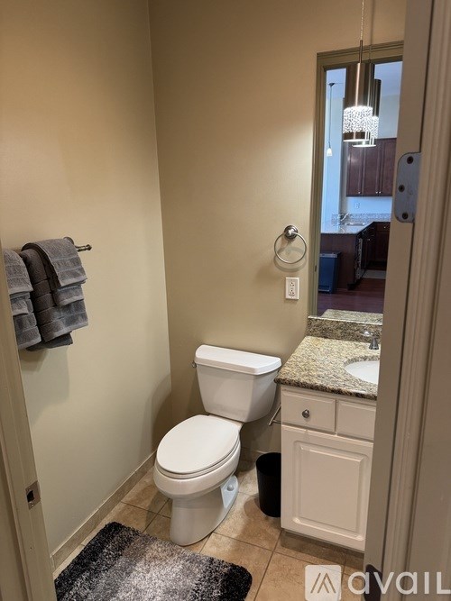 A bathroom with a toilet, sink, and towel rack.