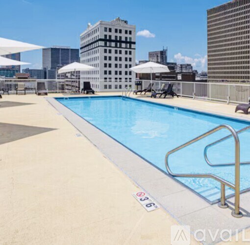 A pool with a metal railing and a white umbrella.