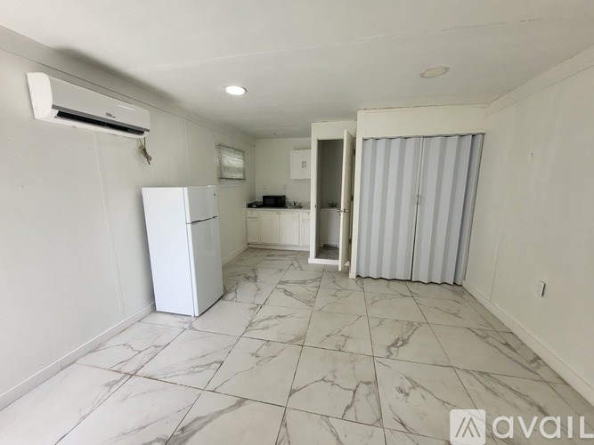 A kitchen with a white fridge and a marble floor.