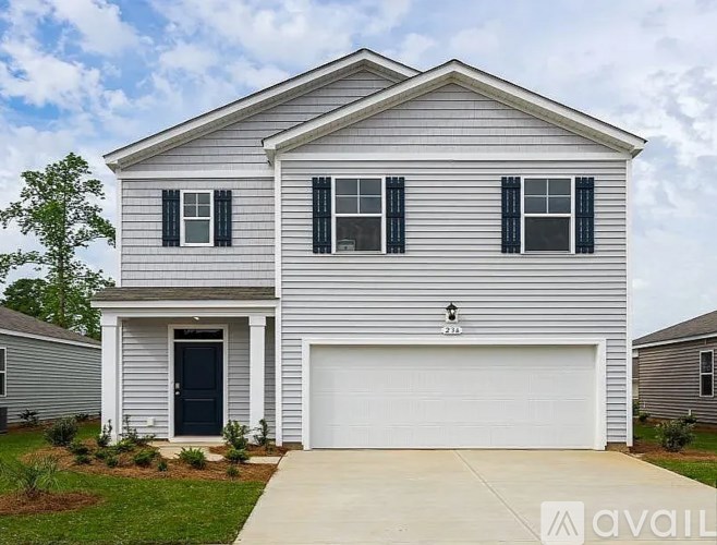 A two-story house with a garage and a driveway.