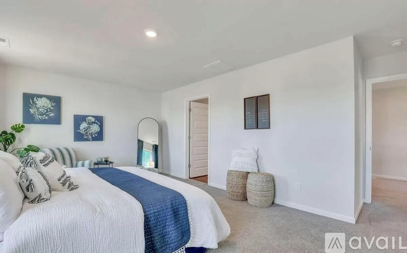 A bedroom with a bed and a blue and white comforter.