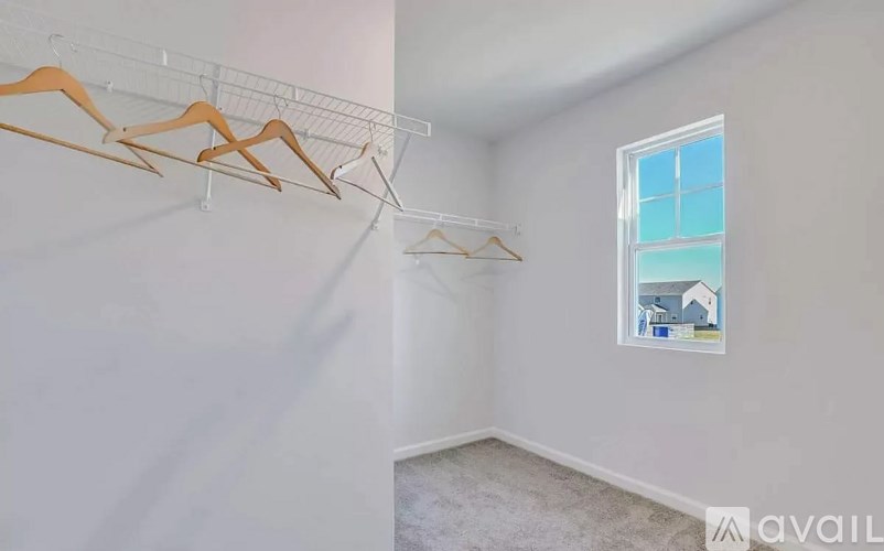 A room with a window and a wall-mounted clothes rack.