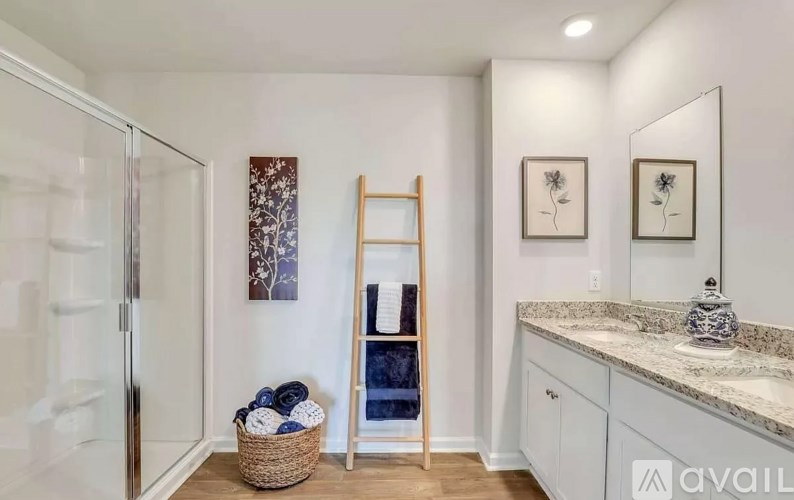 A bathroom with a mirror, sink, and a basket with blue towels.