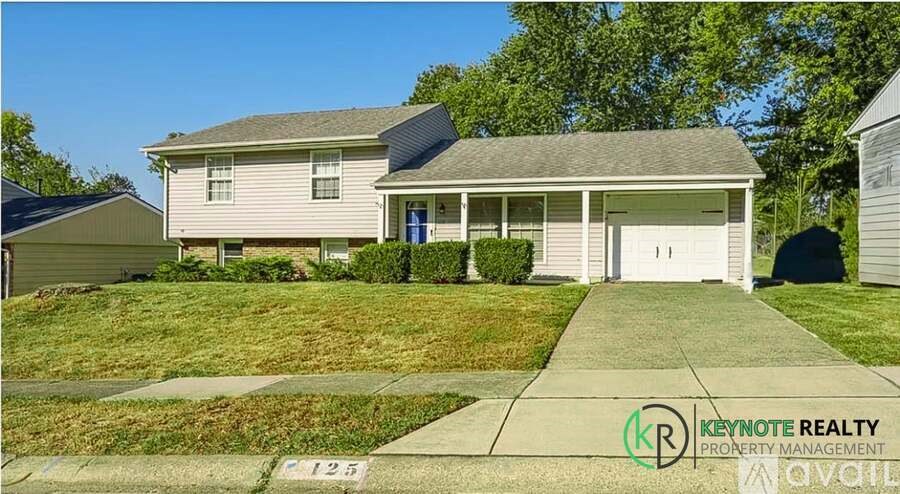 A house with a driveway in front and a sign for Keynote Realty Property Management.