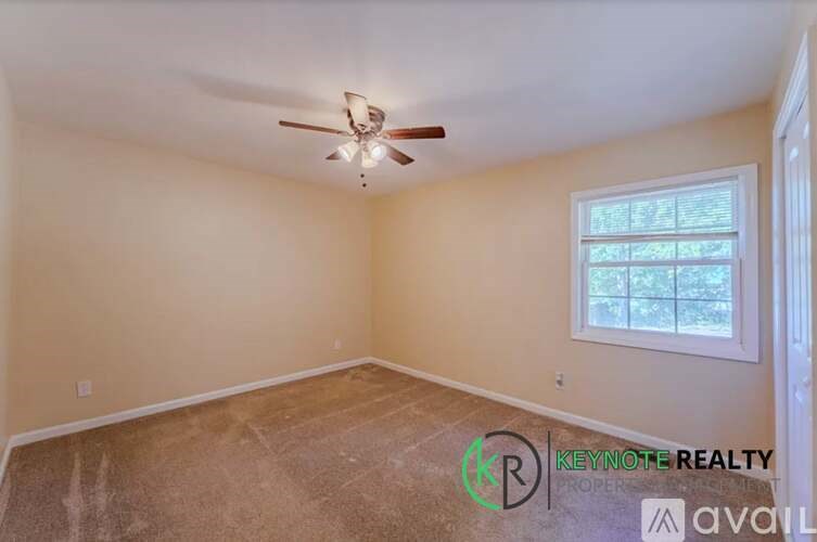 A room with a ceiling fan and a window.