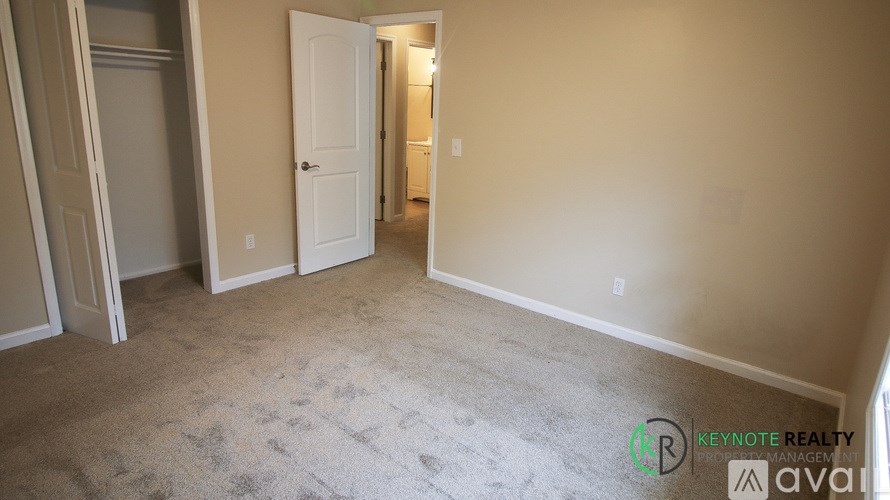A room with a carpeted floor and a doorway leading to another room.