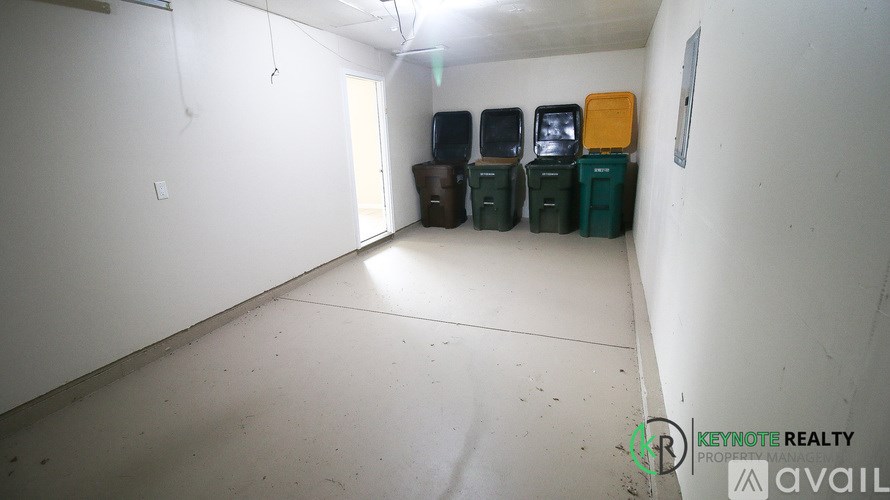 A room with white walls and a white floor with a few boxes on it.