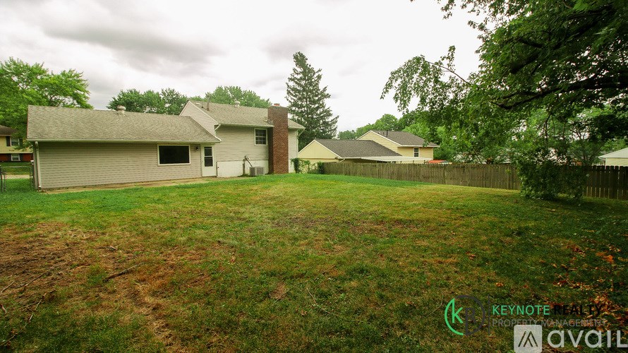 A house with a yard and trees in the background.