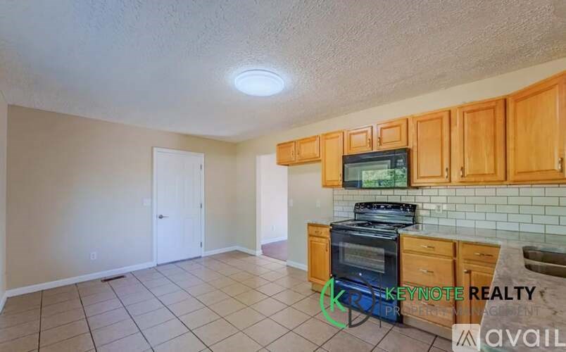 A kitchen with wooden cabinets and a tiled backsplash is available for rent.
