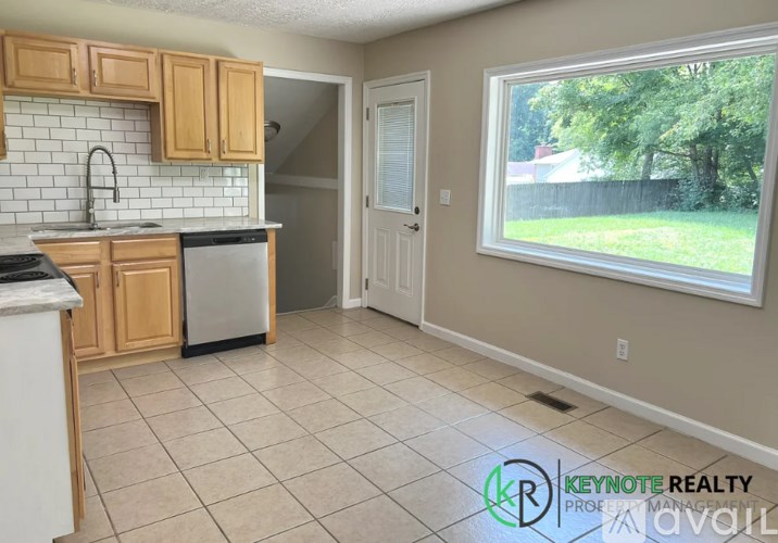 A kitchen with a white countertop and wooden cabinets.