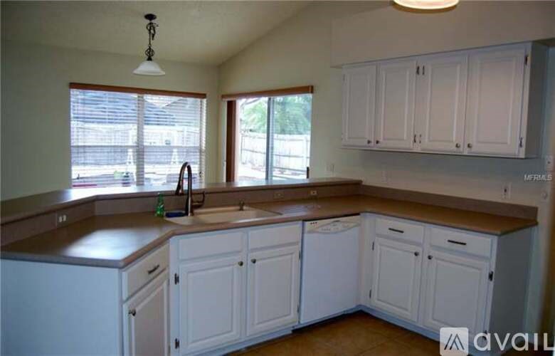 A kitchen with white cabinets and a brown countertop.