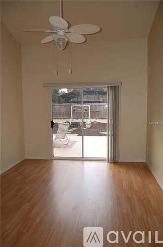 A room with wooden flooring and a ceiling fan.
