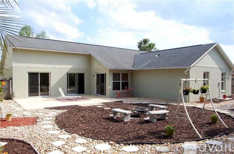 A modern house with a grey roof and a white exterior.