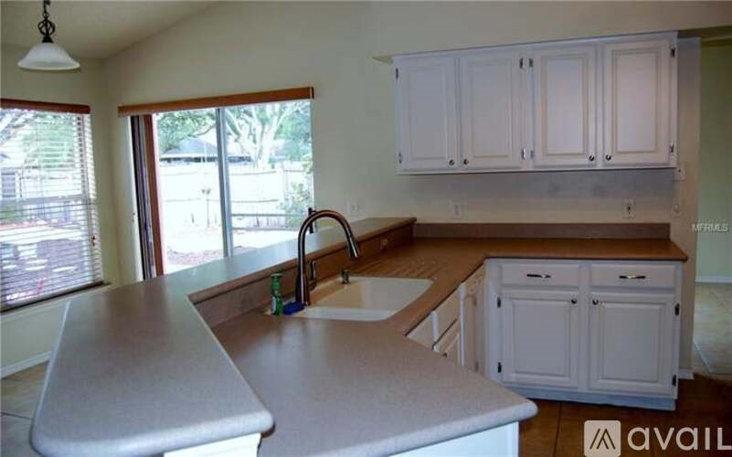 A kitchen with white cabinets and a wooden counter top.