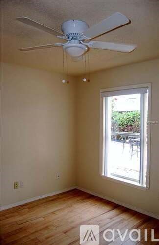 A room with a ceiling fan and a window.