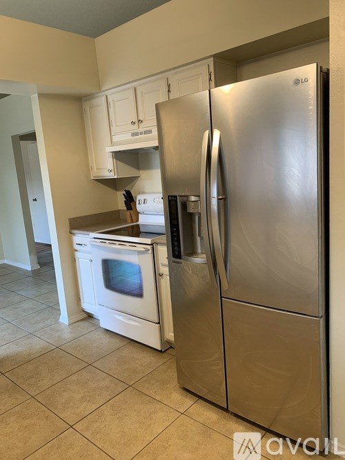 A kitchen with a stainless steel refrigerator and white oven.