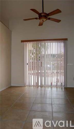A room with a ceiling fan and a sliding door.