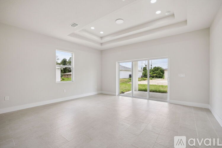 A spacious room with a view of the outdoors through the sliding glass doors.
