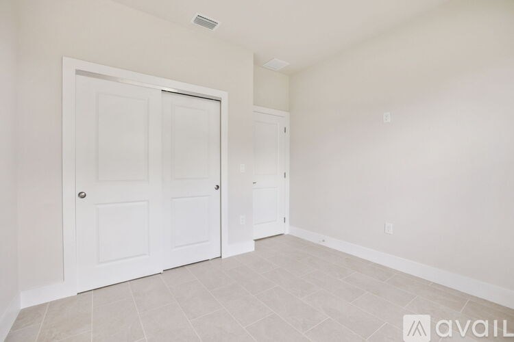 A room with two doors and a tiled floor.