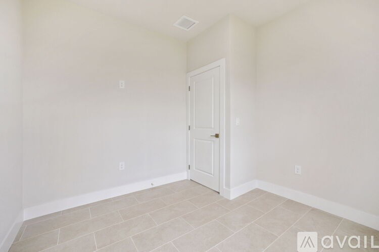 A room with a door and tiled floor.