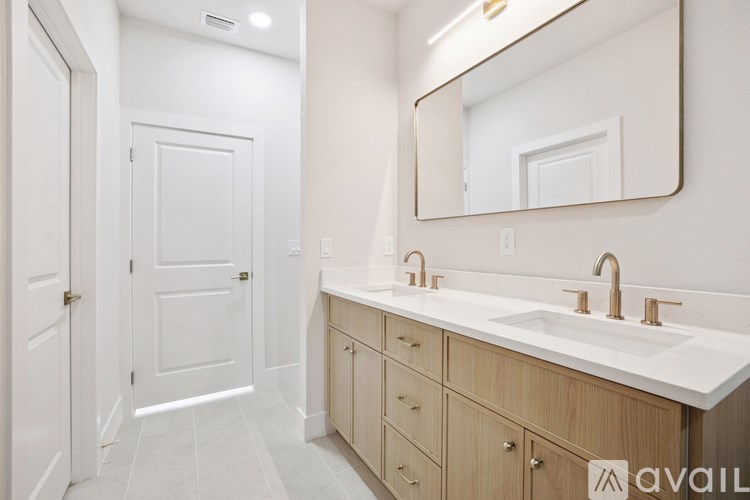 A bathroom with a sink, mirror, and wooden cabinets.