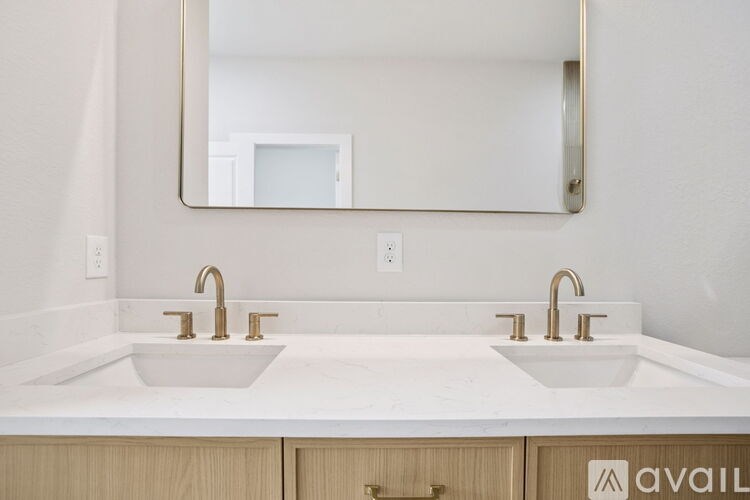 A bathroom with two sinks and a mirror above them.