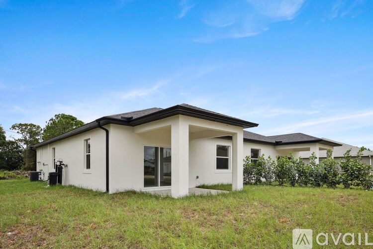 A house with a white exterior and a black roof is available for sale.