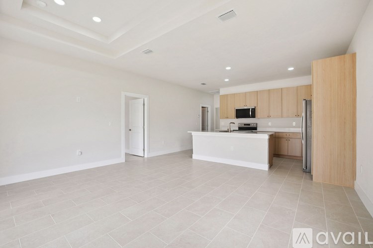 A spacious kitchen with a white countertop and wooden cabinets.