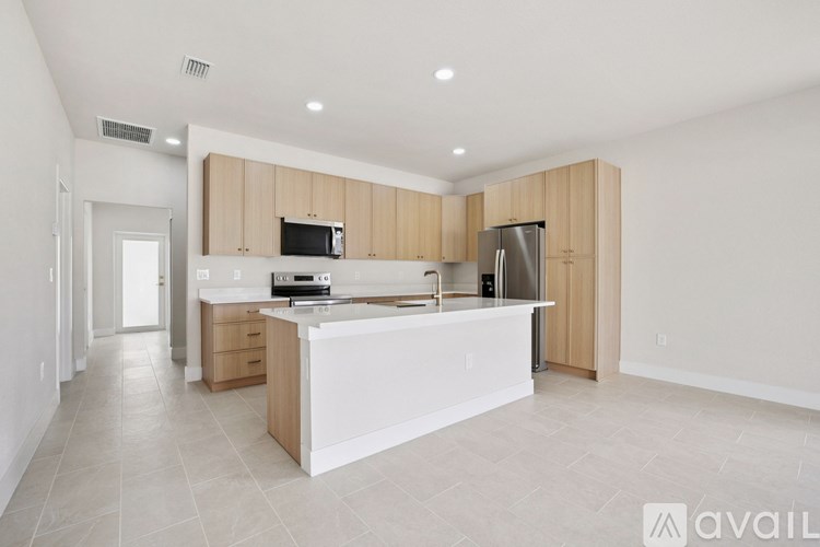 A modern kitchen with a white island and wooden cabinets.