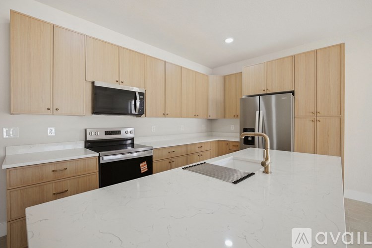 A kitchen with wooden cabinets and a white marble countertop.