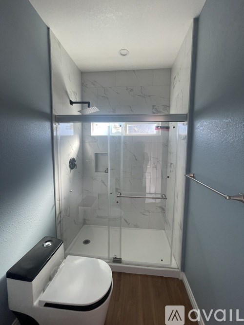 A bathroom with a toilet, sink, and shower.