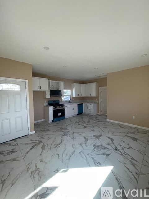 A kitchen with marble flooring and a white door.